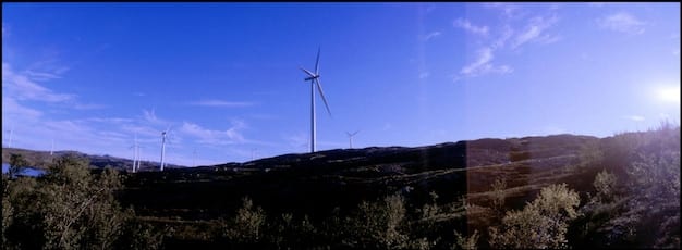 A split image showing on one side a bustling renewable energy farm with wind turbines and solar panels, and on the other side a traditional coal power plant emitting smoke, symbolizing the transition from fossil fuels to clean energy.