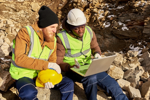 A team in hard hats and safety vests inspecting equipment at a construction site for environmental compliance, showing a practical application of environmental regulations.