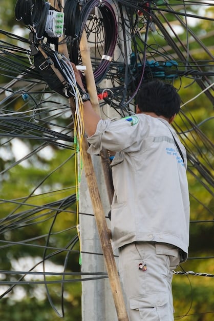 Technicians installing fiber optic cables in a rural area, representing the expansion of broadband internet access.