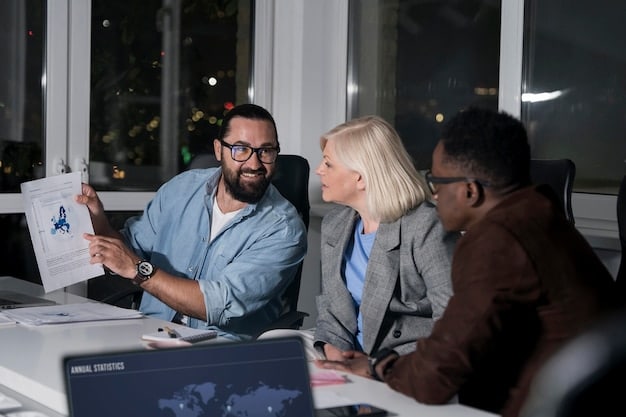 A group of business professionals collaborating around a table, smiling and pointing at a chart showing upward growth trends.