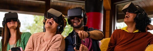 A close-up of a diverse group of people wearing VR headsets, smiling and gesturing, indicating a positive and engaging virtual experience.