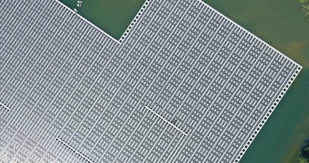 An aerial view of a sprawling, modern solar panel manufacturing facility in the US, with workers in clean suits assembling panels and raw materials being moved by automated systems, symbolizing advanced domestic production.