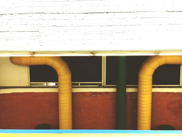 A geothermal heating system being installed in the basement of a house. The system includes pipes, pumps, and a heat exchanger. The house appears to be modern and energy-efficient.