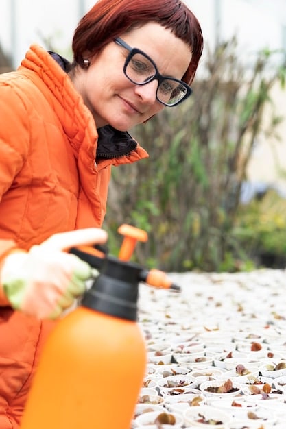 A researcher releasing a biological control agent, such as a specific insect, onto an invasive plant in a US National Park, demonstrating the practical application of this strategy in managing invasive species.