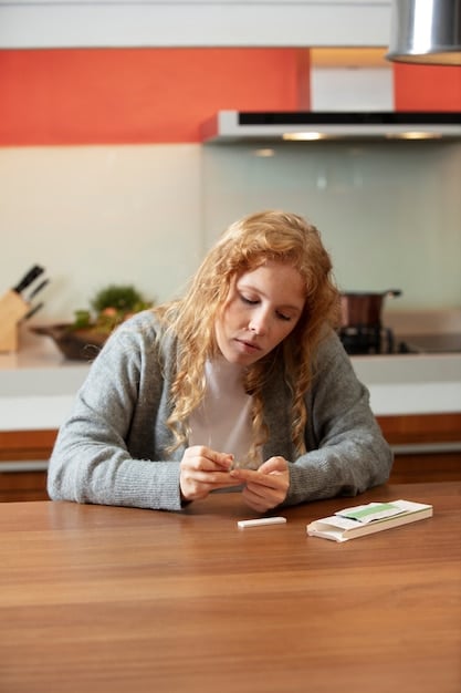 A young woman is thoughtfully examining the water bill on her kitchen table, looking at sections highlighted in red. A half-filled glass of water is also sitting on the table, along with a pencil and some notes. Natural light streams in from a nearby window.
