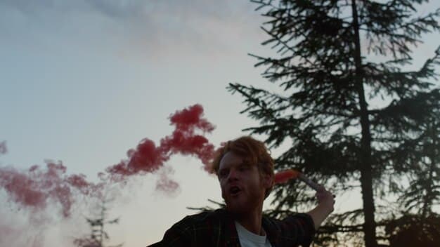 A close-up shot of a person using an inhaler against a blurred background of smoky, hazy air, emphasizing the respiratory impact of wildfires.
