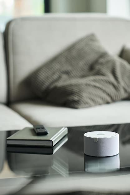 A close-up of a smart thermostat on a wall, displaying a low temperature, with a blurred background of a cozy living room, illustrating energy efficiency.